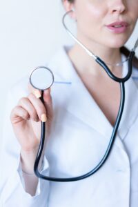 une femme en chemise blanche tenant un stéthoscope