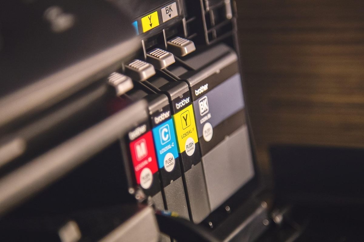 Cartouches d'encre rouge, bleu, jaune et noire installées dans une imprimante