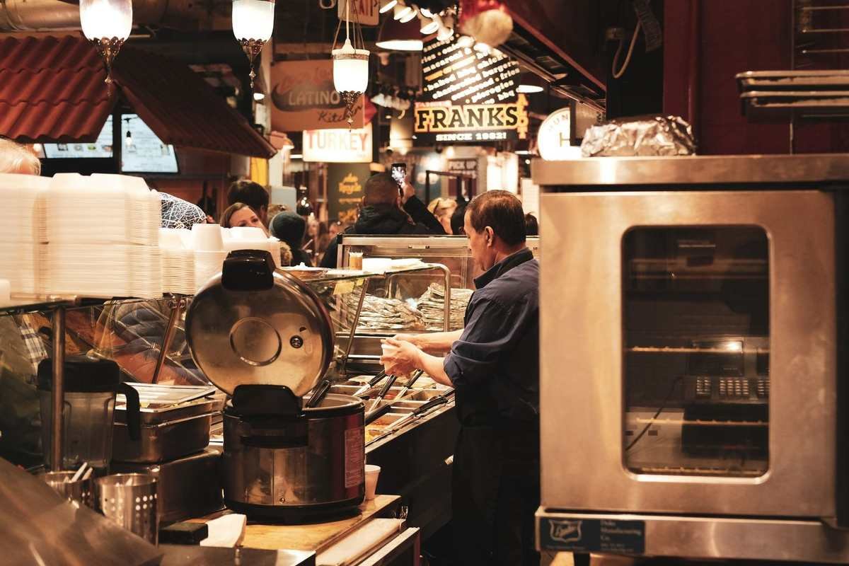 Cuisinier en action dans une cuisine équipée de plaques et d'un four Cuisinier en action dans une cuisine équipée de plaques et d'un four