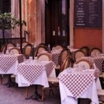 Tables et chaises disposées devant un restaurant avec menu affiché