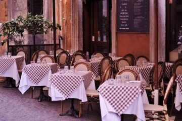 Tables et chaises disposées devant un restaurant avec menu affiché