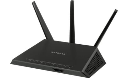 Un routeur Netgear noir à trois antennes posé sur fond blanc